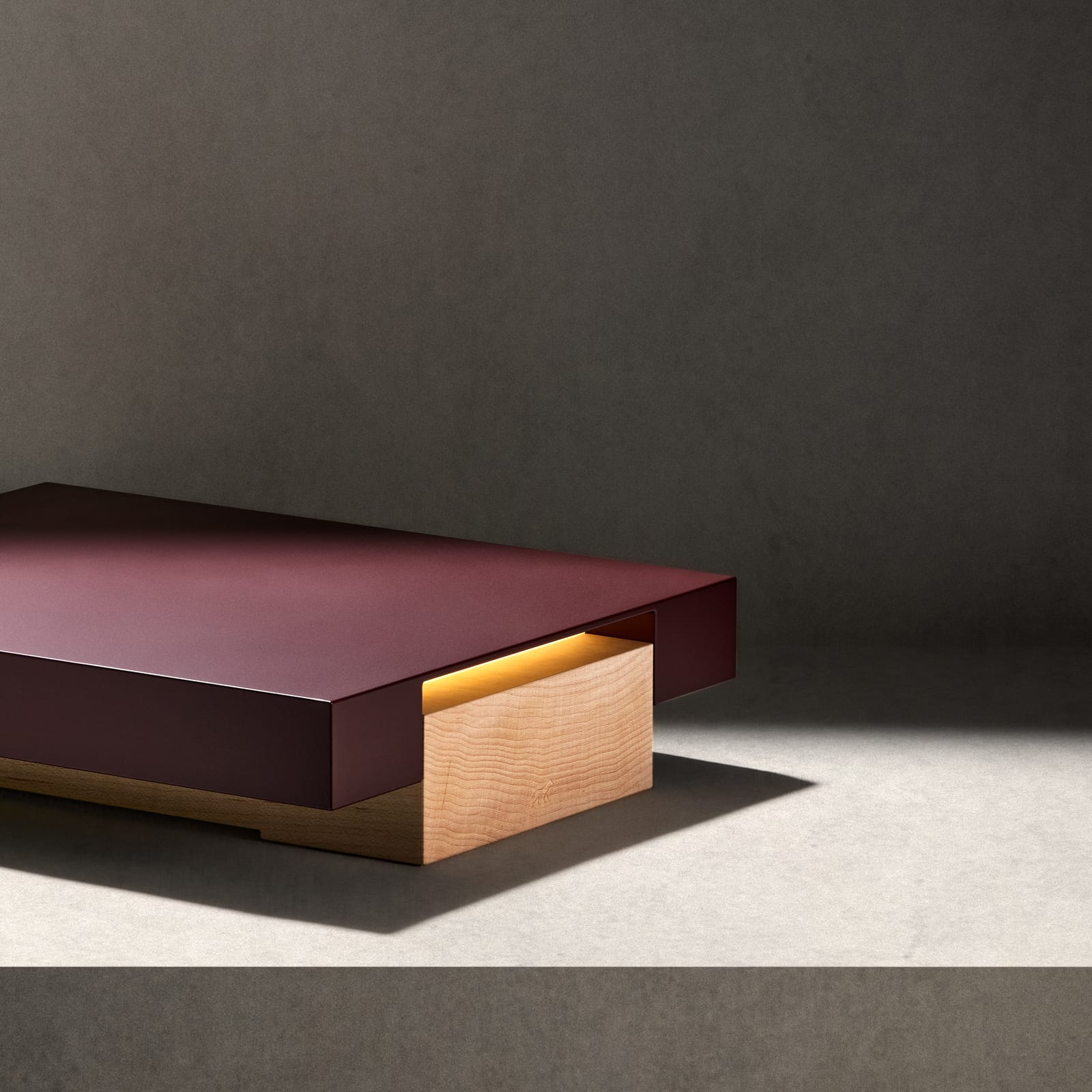 The Vora Aegis on a concrete ledge in a shaft of light, a dark curtain at the edge of the frame.