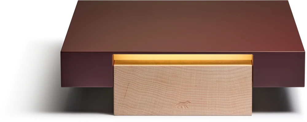 The Vora Aegis appliance: a flat burgundy slab resting on a pale maple base, with warm light glowing from the seam between them.